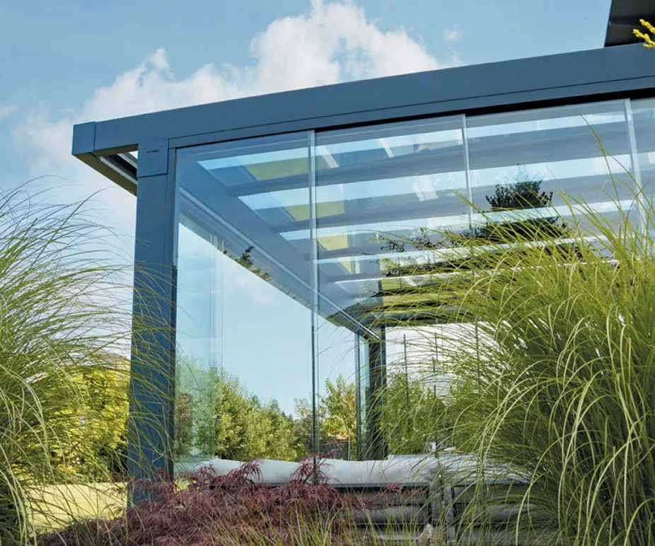 Elegante Aluminiumkonstruktion eines Glasdachs mit seitlichen Glaselementen und Gartenblick