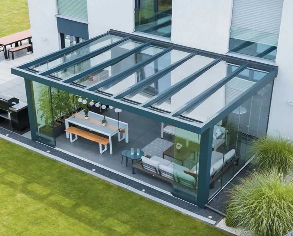 Terrassendach mit Glas und Glasschiebewänden vor modernem Gebäude aus erhöhter Perspektive