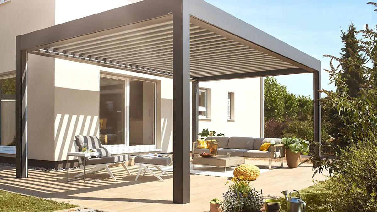 Modernes Lamellendach mit verstellbaren Dachlamellen über einer stilvoll eingerichteten Terrasse